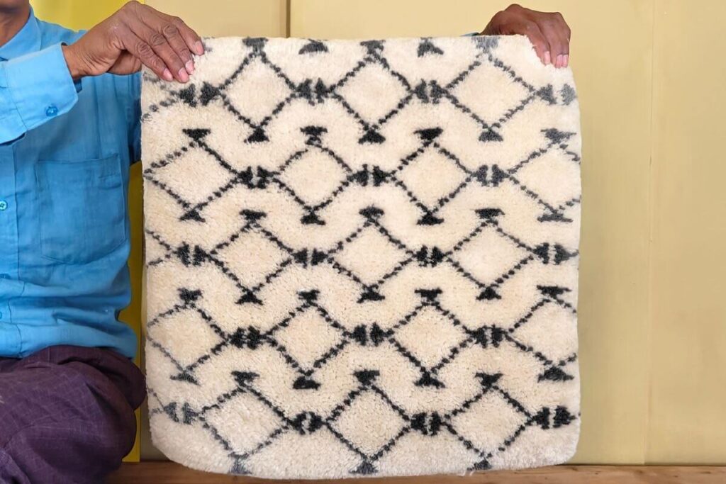 Handmade wool rug sample held to show texture and pattern detail