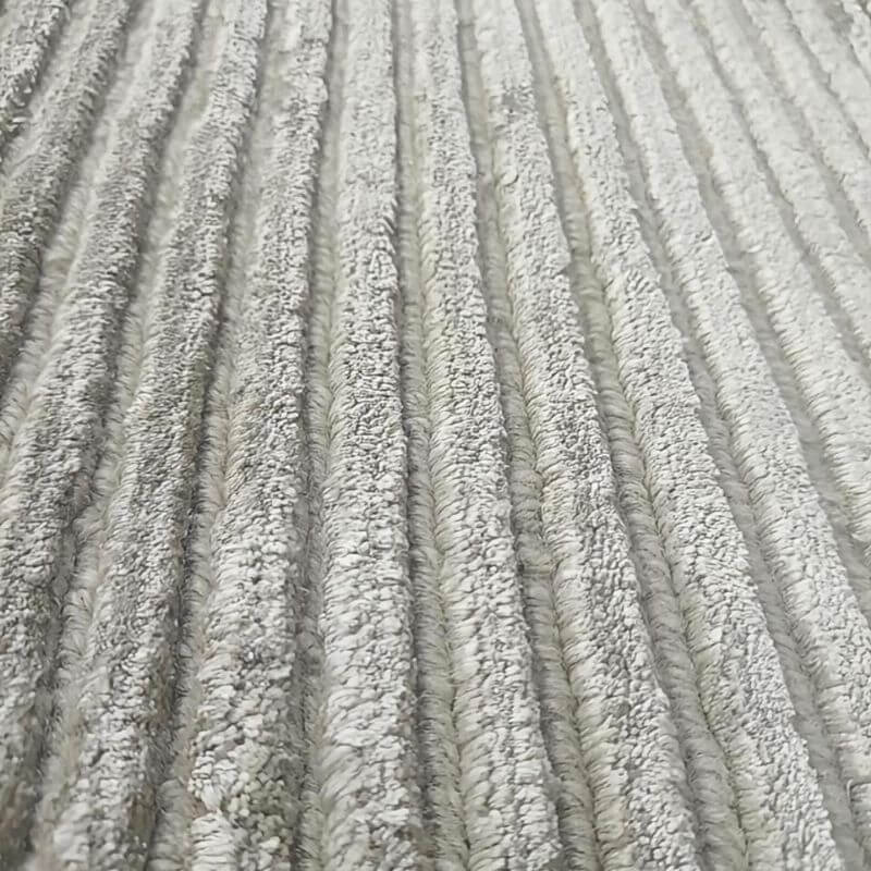 Close up texture detail of the FiRugs Horizon grey rug showing alternating raised viscose cut pile ribs and recessed New Zealand wool loop pile channels.